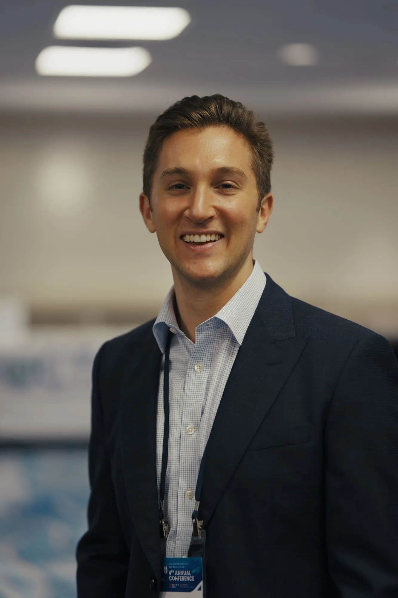 Professional event portrait of a smiling man wearing a navy suit