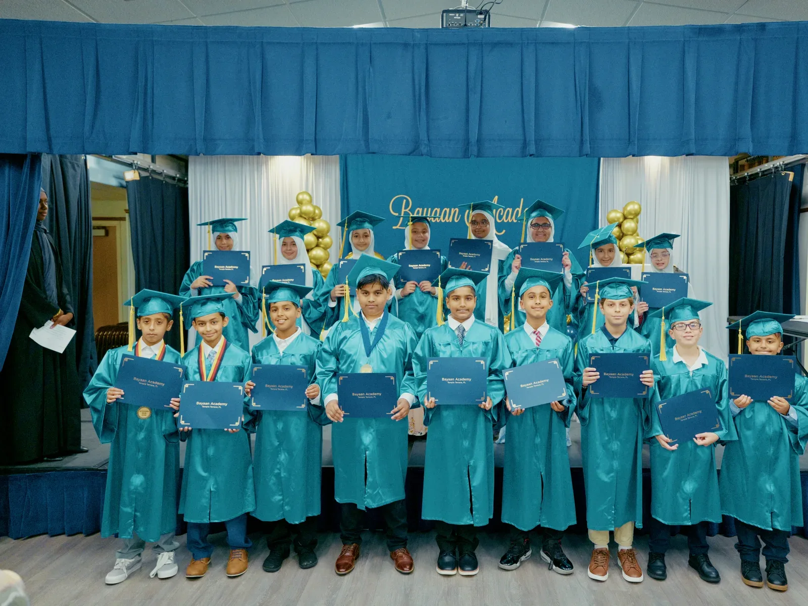 Bayaan Academy kindergarten graduates posing together after their ceremony