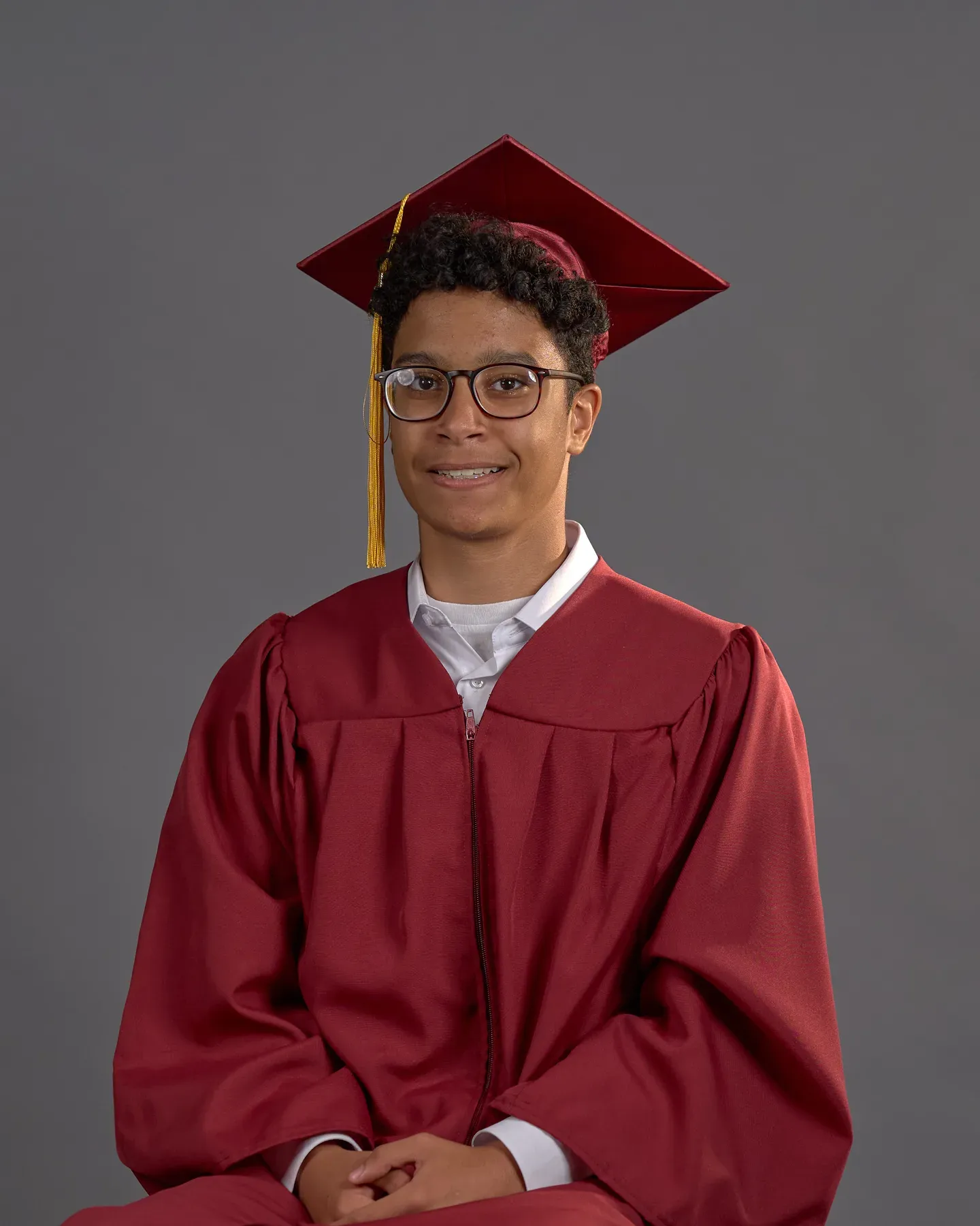 Bayaan Academy graduate wearing a red cap and gown