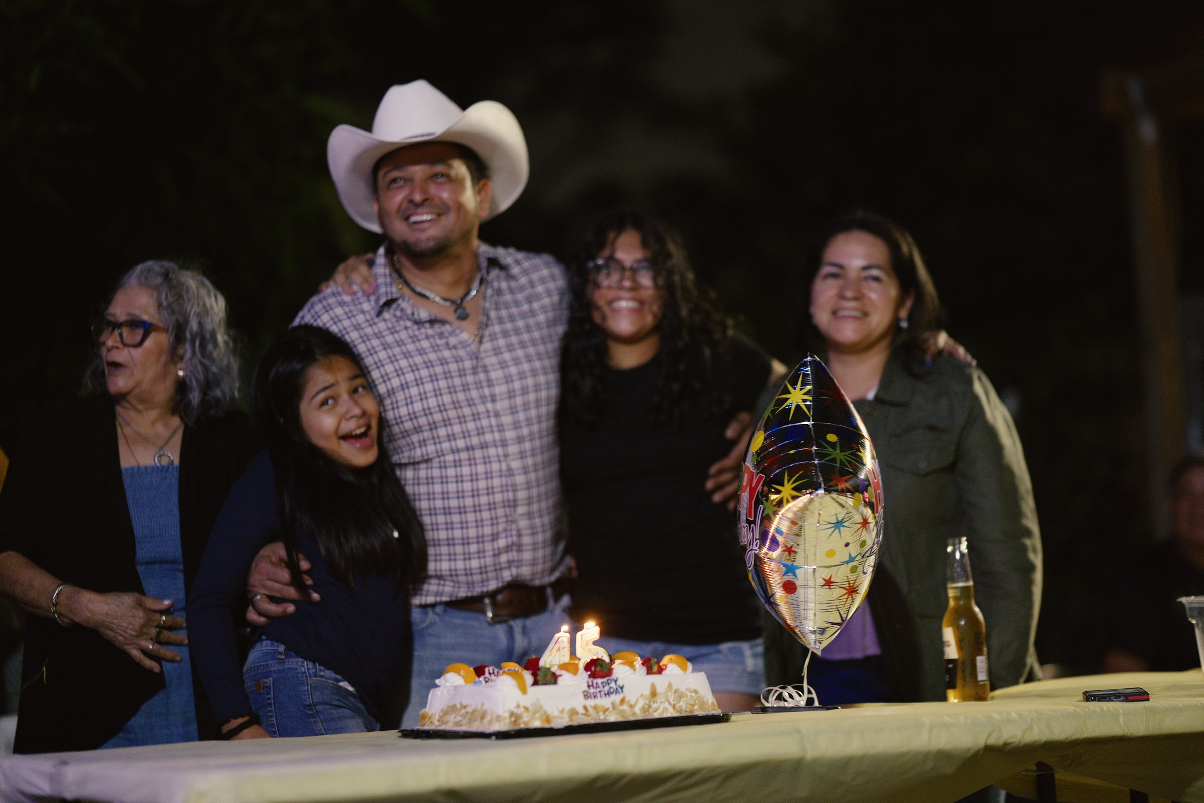Angel celebrating his birthday with family around the cake